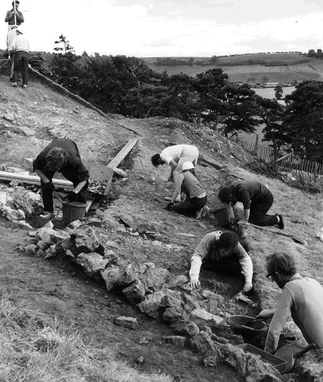 Археологи работают на заваленном камнями склоне холма на известном памятнике Камелота, дворца короля Артура в Кэдбюри на юго-западе Англии 