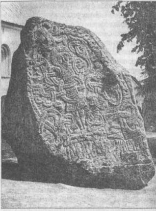 Рис. 124. Еллингский камень Одна из сторон камня из Еллинге показывает сцену распятия. Христос окружен плетением, часть рунической надписи можно увидеть на основании камня. Около 980 г.